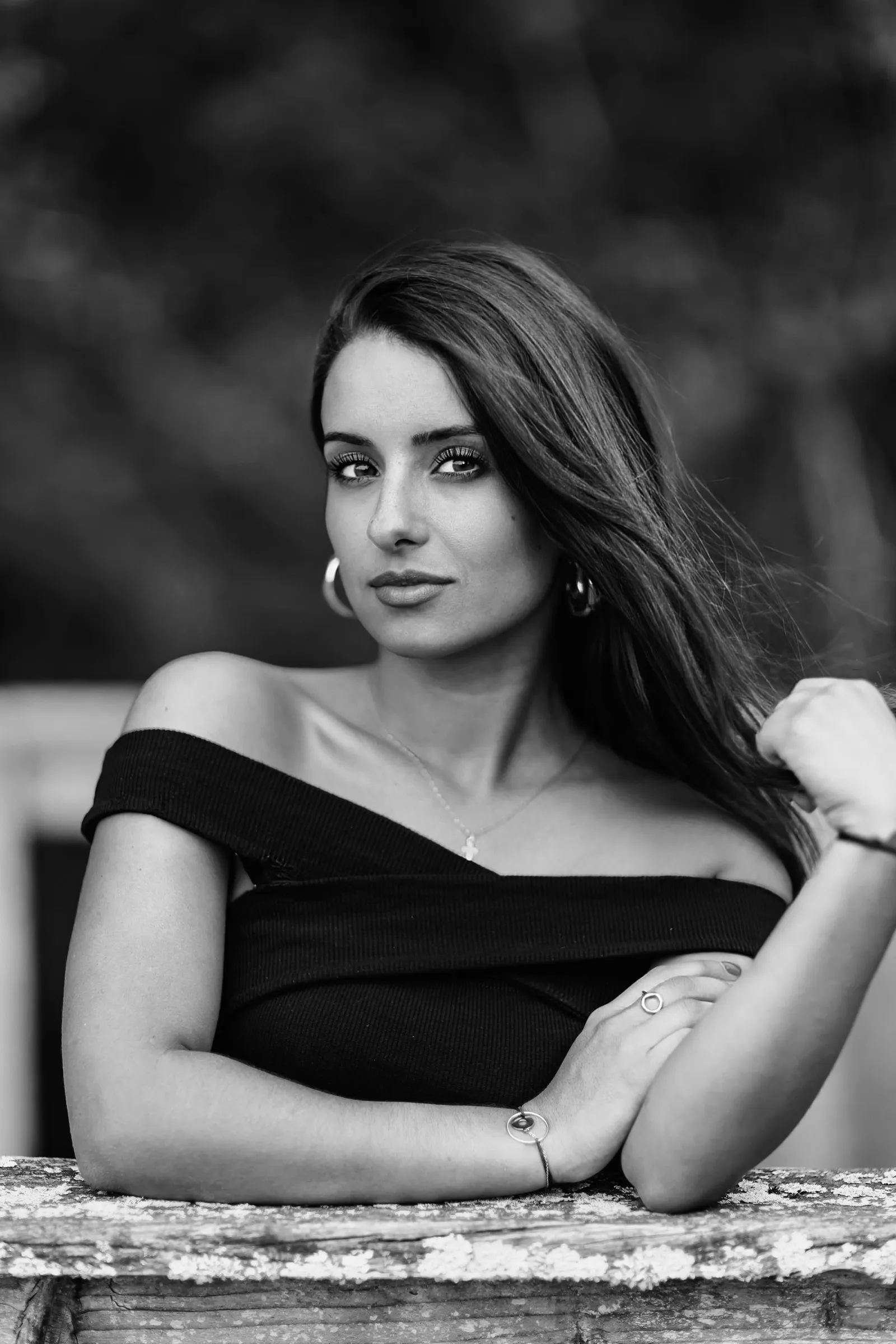 Portrait de femme en extérieur en noir et blanc, accoudée à un muret