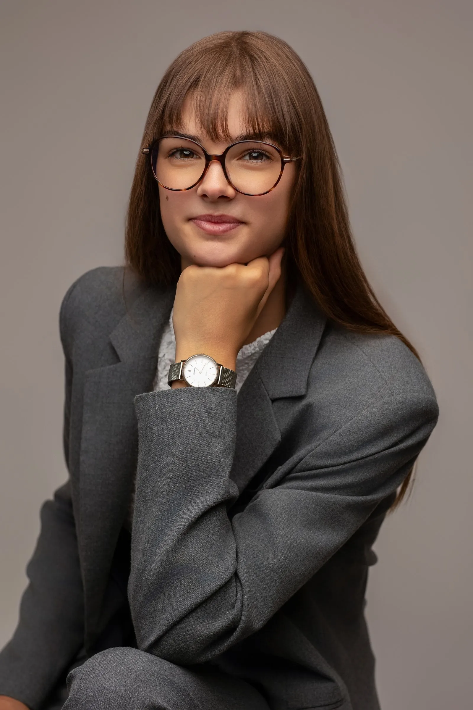 Portrait professionnel en blazer gris et lunettes, studio près de Toulouse