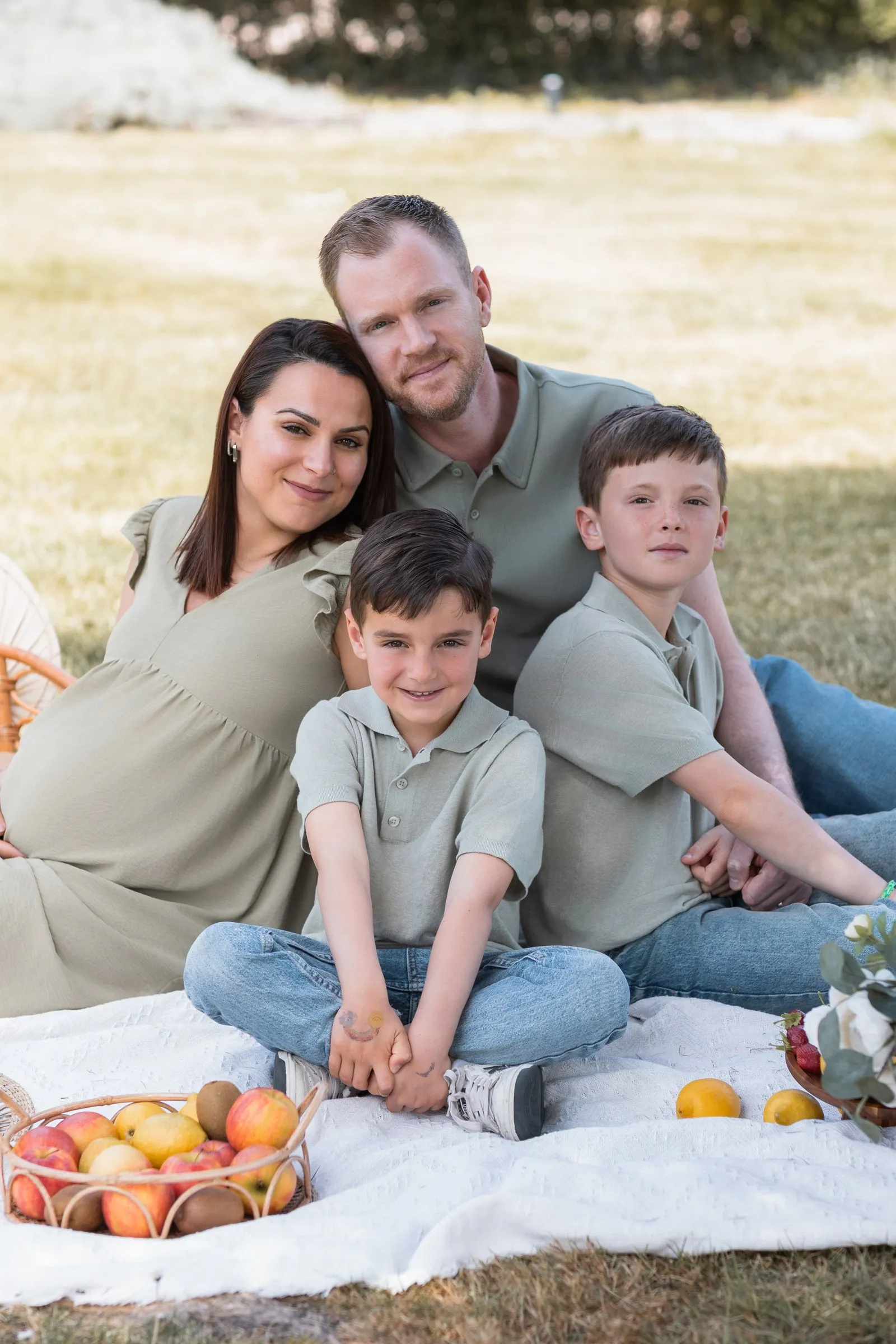 Famille avec deux garçons en pique-nique dans l'herbe, séance en extérieur près de Toulouse