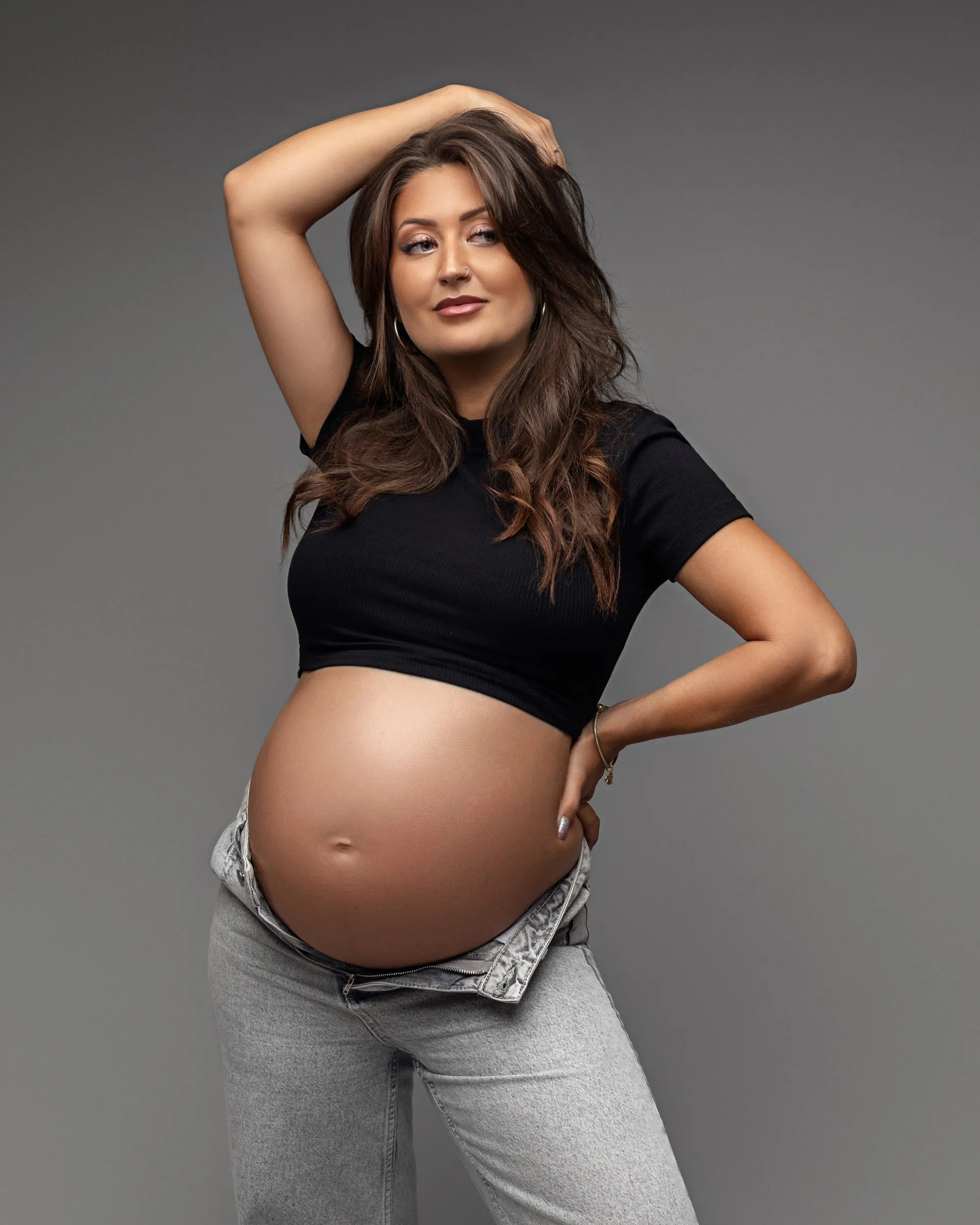 Future maman en crop top noir et jean, séance photo grossesse en studio près de Toulouse