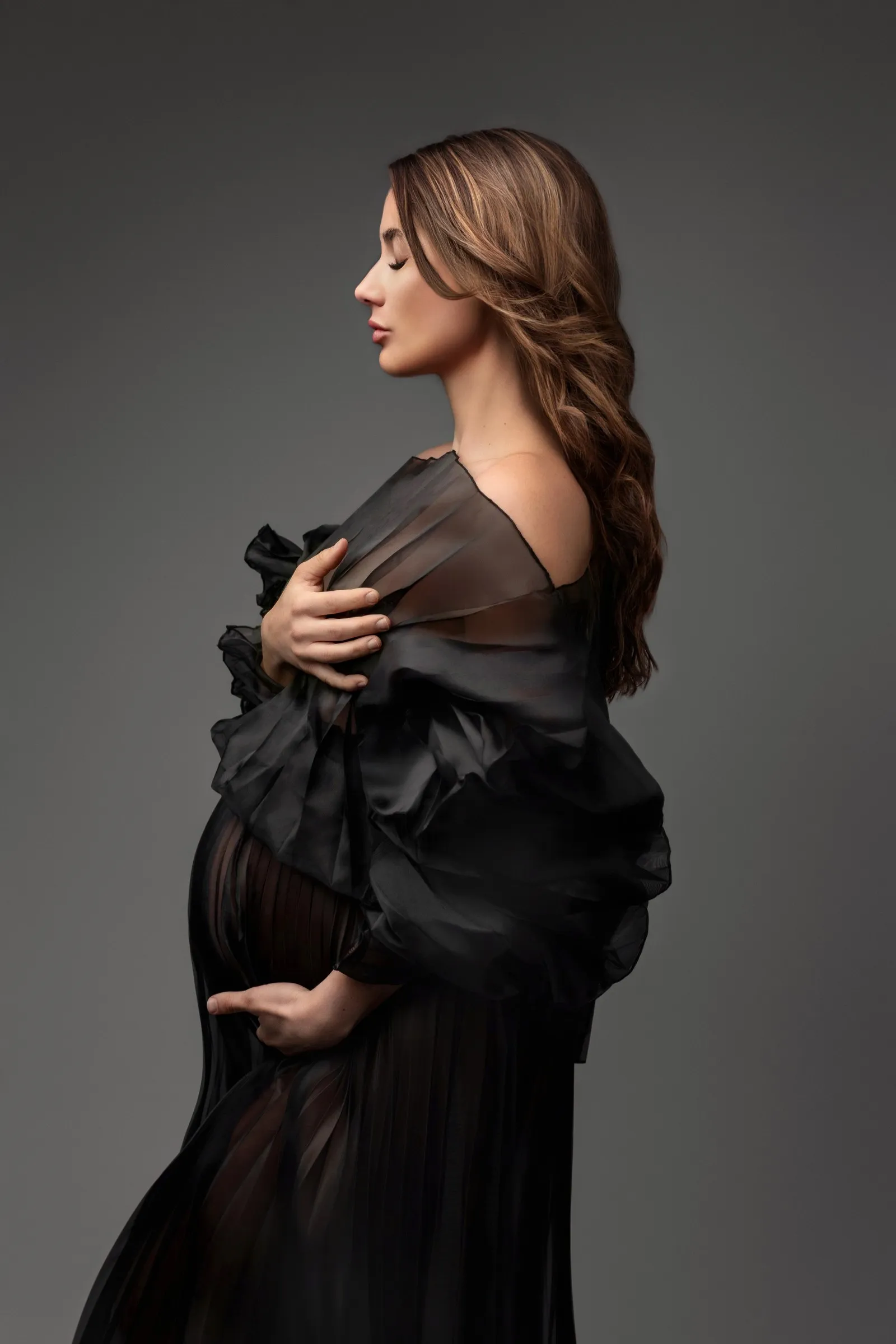 Future maman de profil en robe d'organza noire, séance photo grossesse en studio près de Toulouse, Emilie Colusso photographe