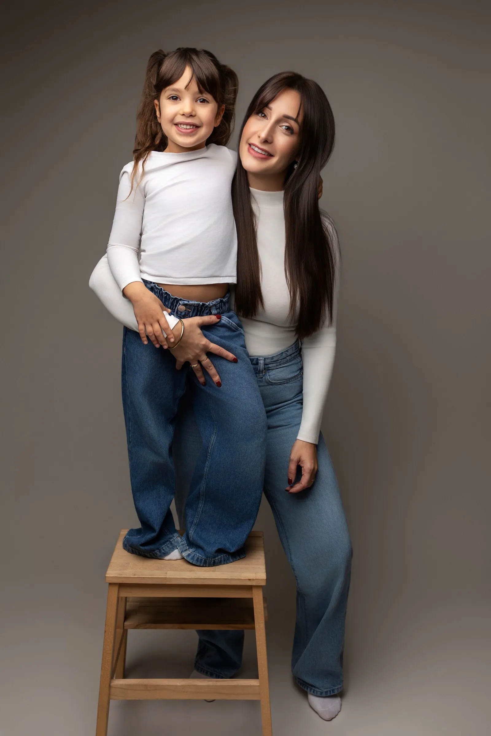 Maman et sa fille debout sur un tabouret, séance photo famille en studio