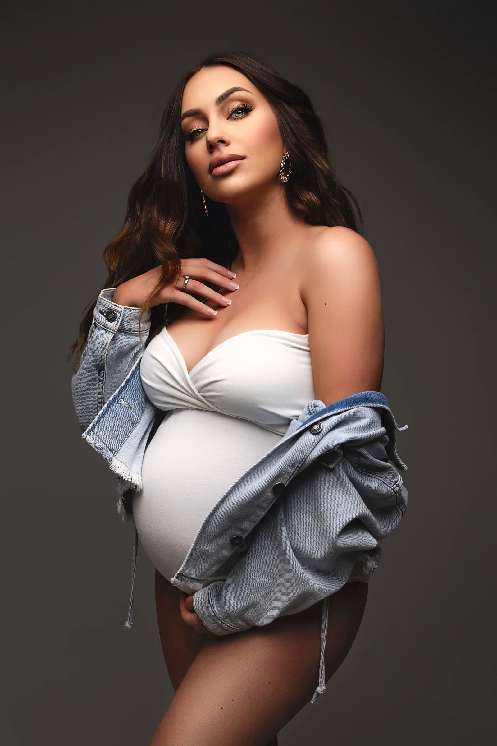 Future maman en veste en jean sur l'épaule, séance photo grossesse en studio, Emilie Colusso photographe