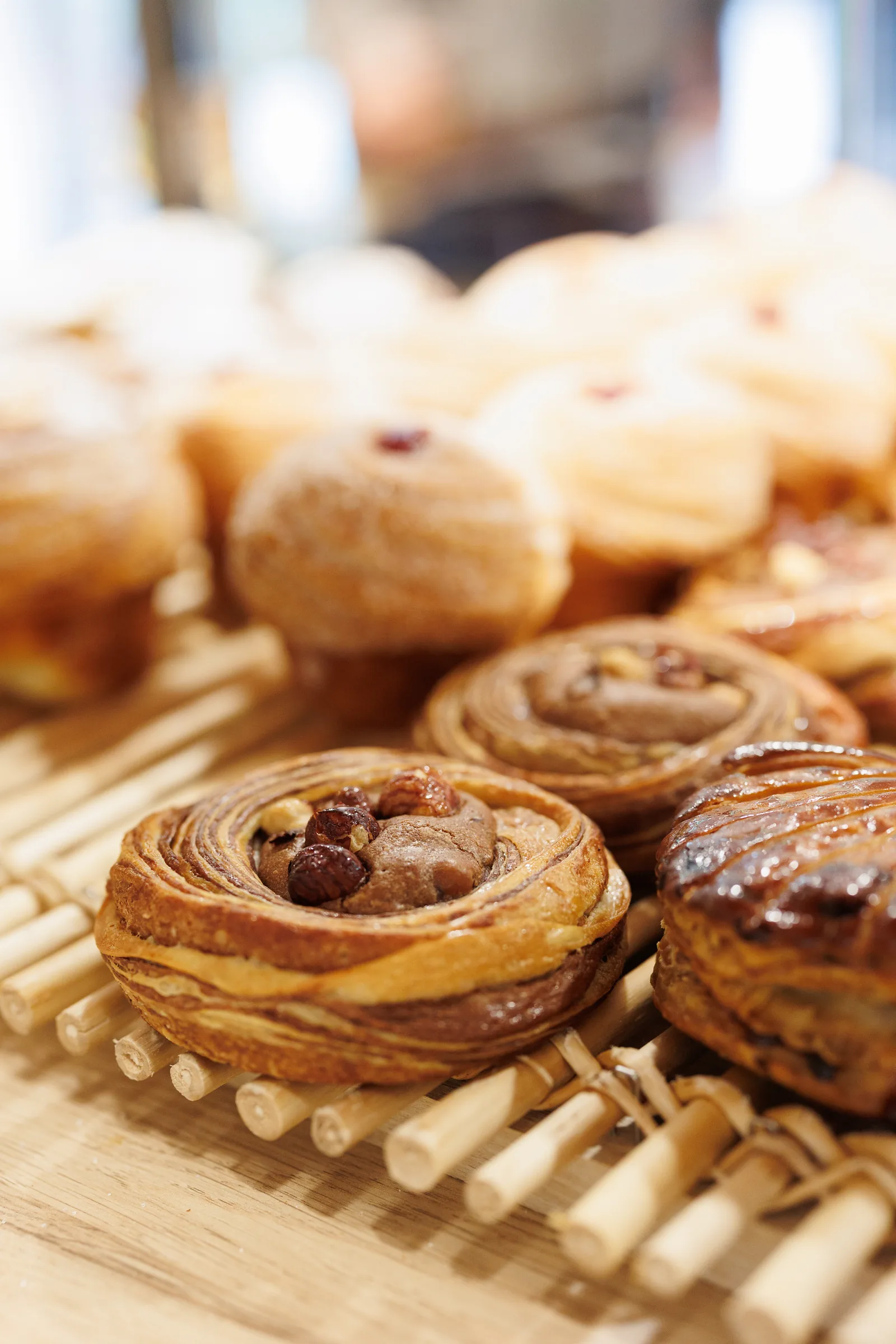 Viennoiseries feuilletées aux noisettes sur une clayette en bois, photo produit pour la boulangerie bio Au Pain par Nature à Cugnaux, Emilie Colusso photographe