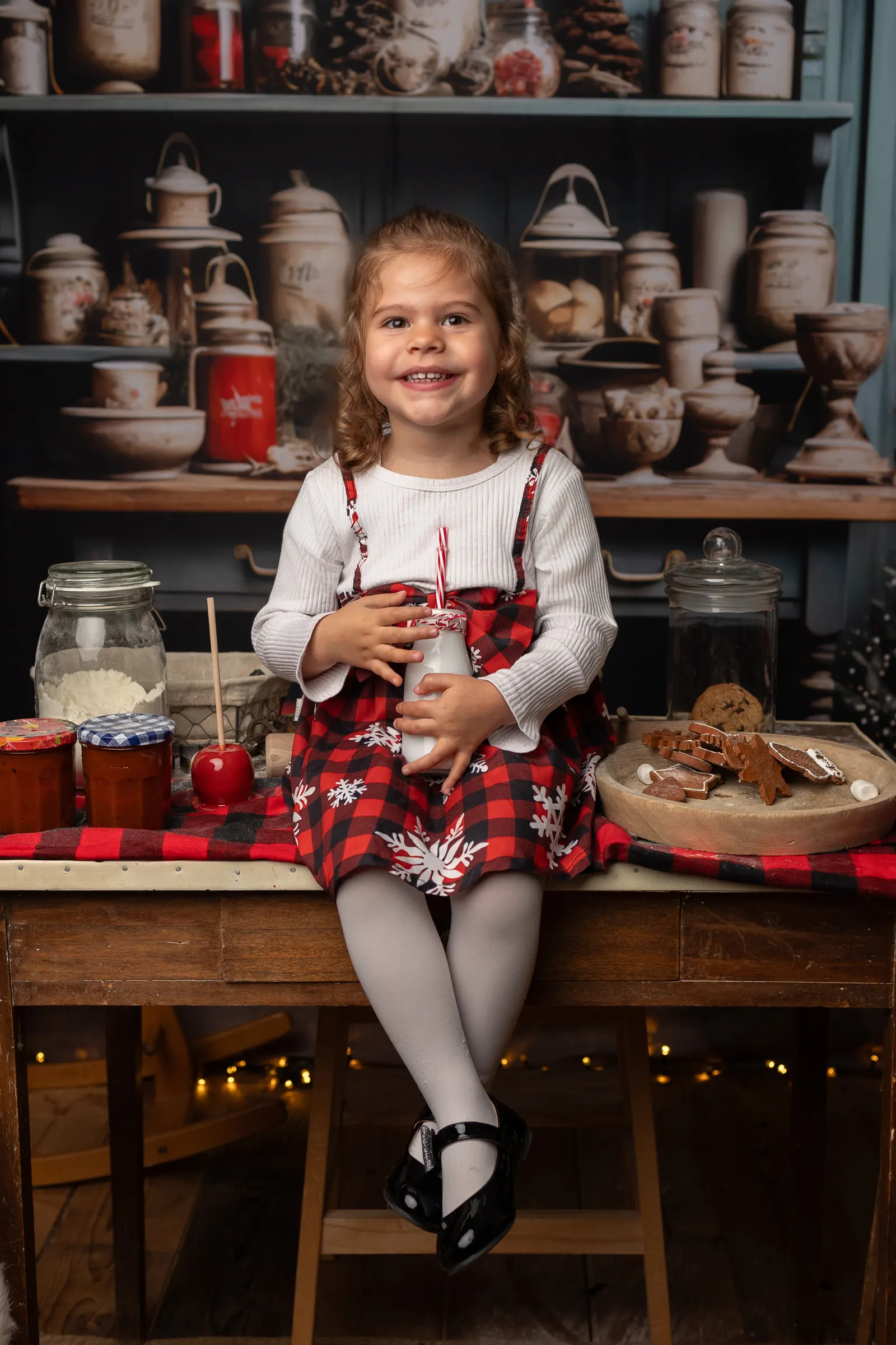 Petite fille dans le décor cuisine de Noël avec le Père Noël, mini séance au studio